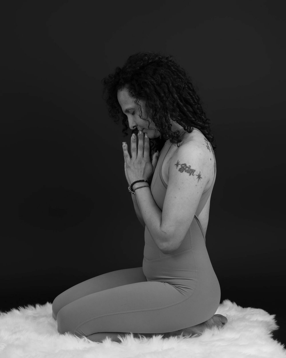 Alee kneeling with hands at her heart